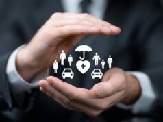 Businessperson’s hands forming a protective gesture around icons representing health, family, and car insurance